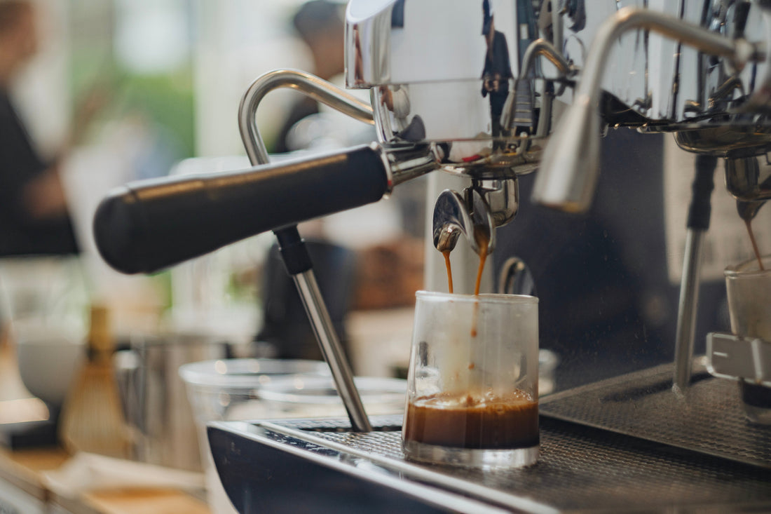 Recommended: Espresso machine brewing coffee in a cafe to represent the Swiss Water® Process Death to Death Before Decaf blog.