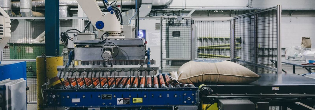 Factory scene at Swiss Water Process showing a conveyor belt and a sack of coffee where amazing coffee without caffeine comes from.