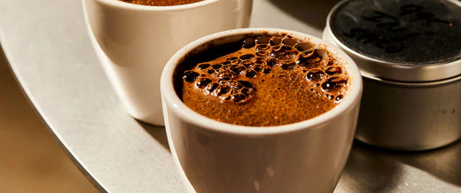Cups of coffee being brewed for evaluation in small ceramic cups. Swiss Water Blog They Didn't Know it Was Decaf