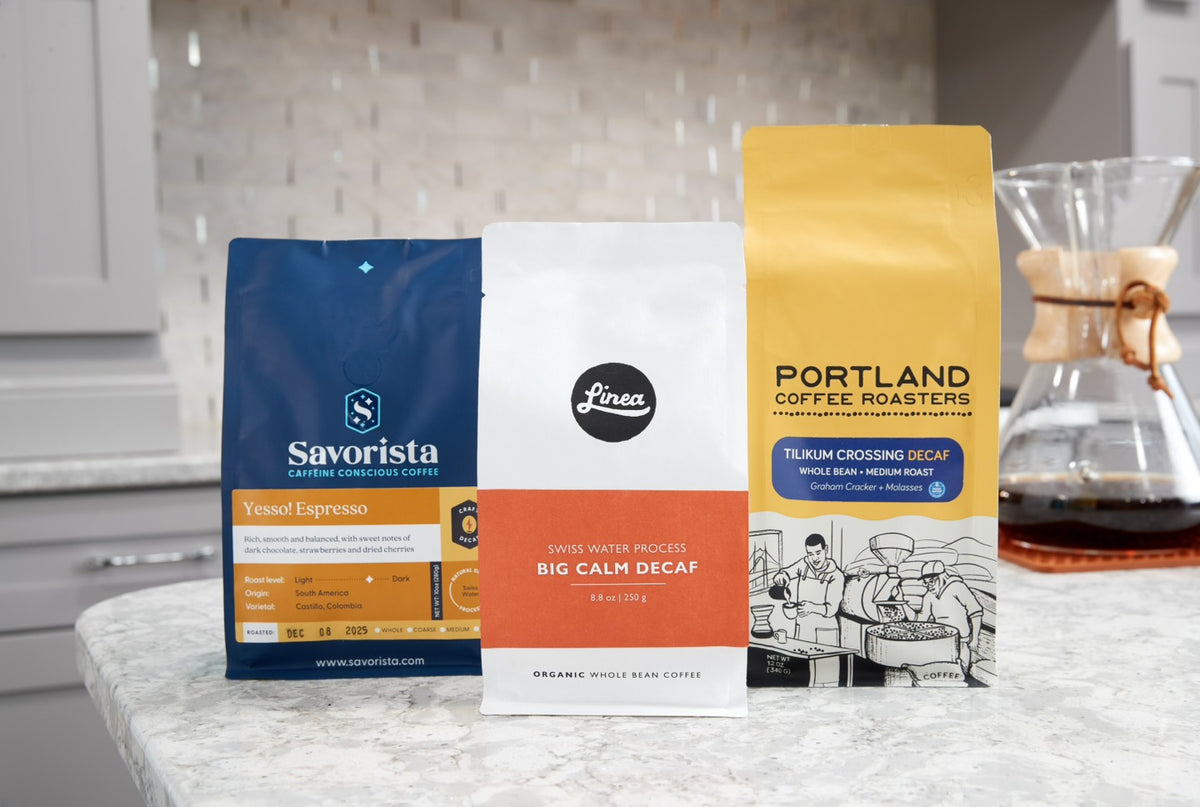 Three coffee packages from Savorista, Linea, and Portland Coffee Roasters on a kitchen counter.