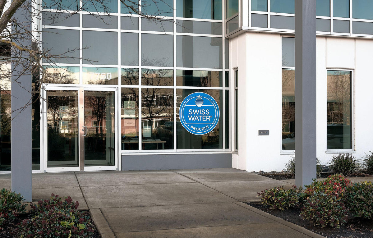 Building exterior with a Swiss Water logo on a glass panel