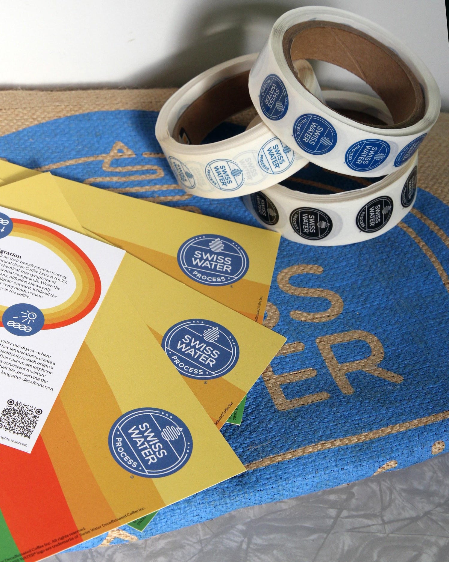 Two rolls of Swiss Water branded stickers and a few process cards.